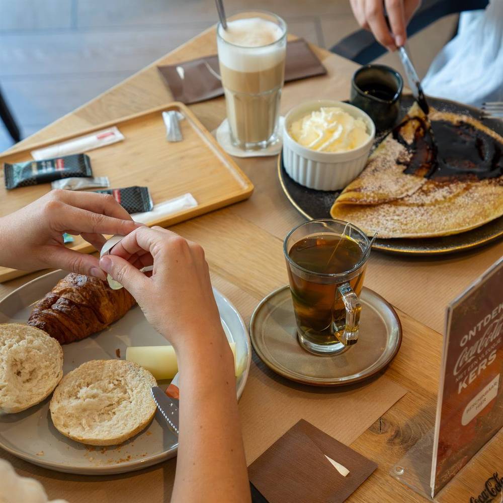 Binnen bij KOP: latte macchiato, verse thee, croissant en een pannenkoek met chocoladesaus.
