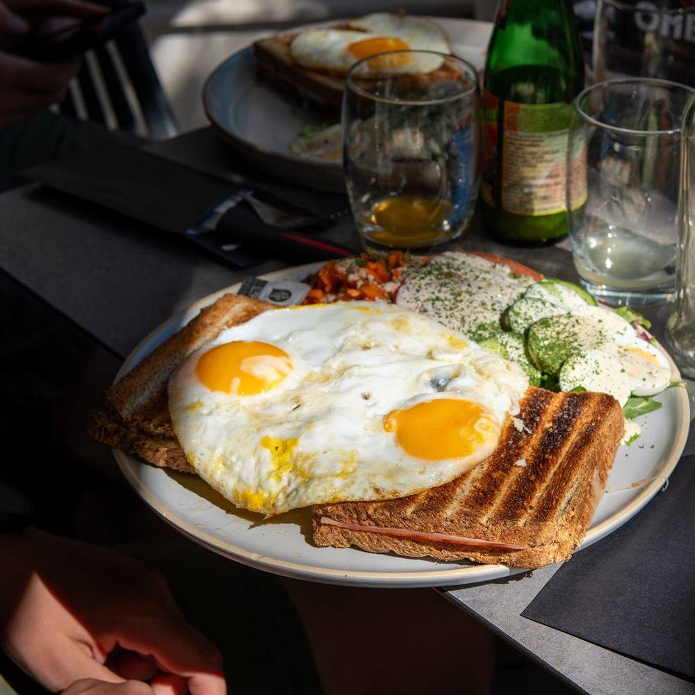 Uitsmijter met twee spiegeleieren, een croque en een frisse salade.