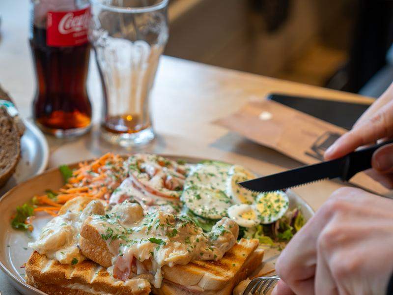 Een flesje Coca-Cola bij een croque met salade.
