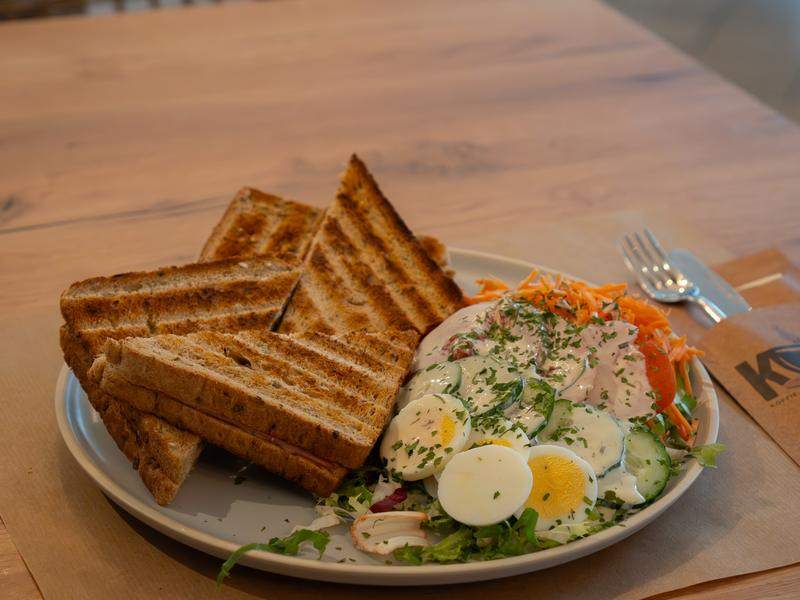 Een croque met een frisse salade, ei en groenten.