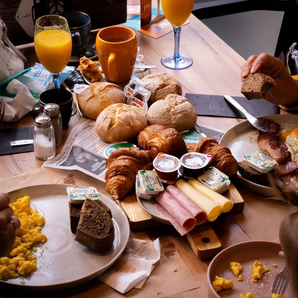 Een volle ontbijttafel bij KOP: croissants, broodjes, eitjes, sap en koffie.