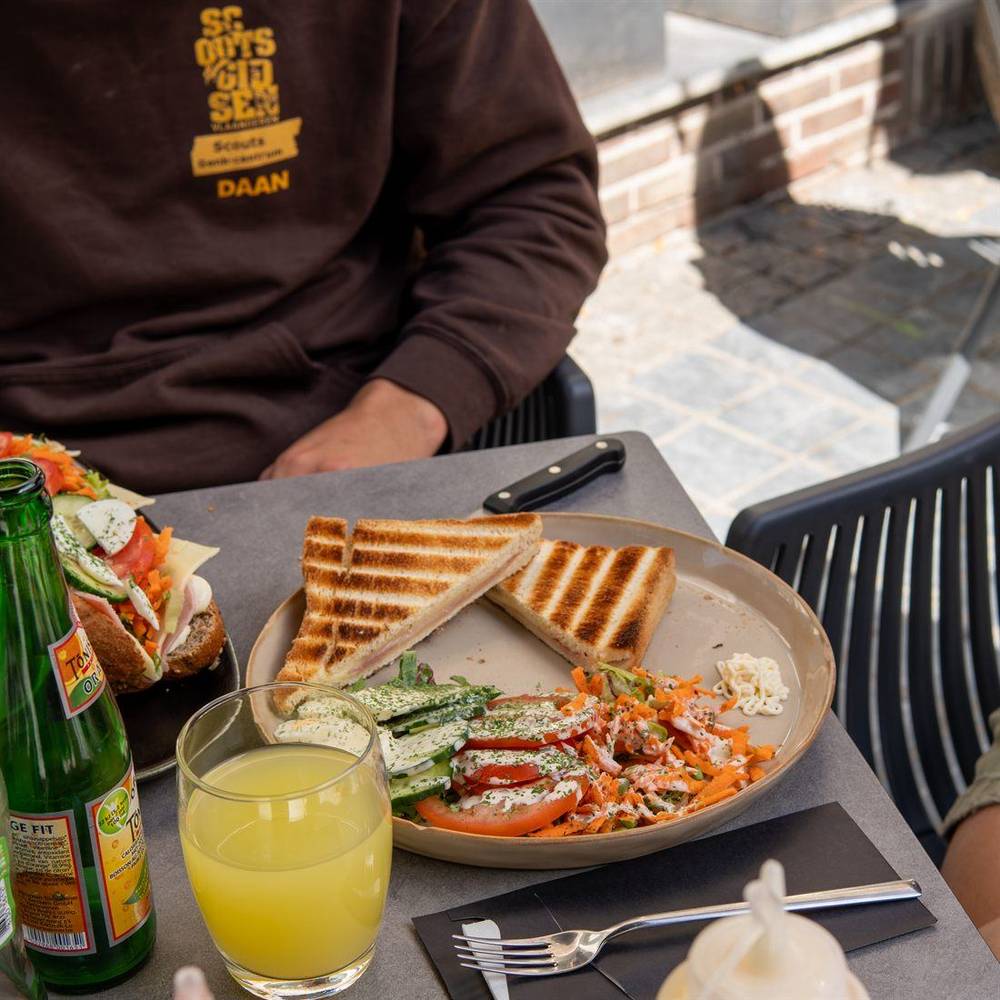 Twee gasten aan een tafel op het terras met een croque en een broodje.